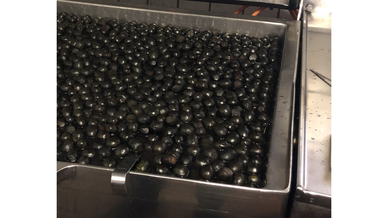das mehrmalige Kochen der schwarzen Baumnüsse im Zucker Sud mit verschiedenen Gewürzen