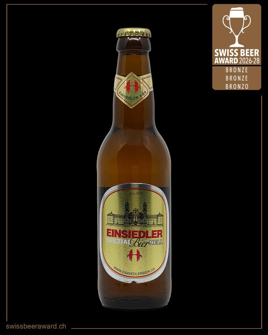 Eine Flasche Einsiedler Spezialbier Hell mit goldenem und rotem Etikett, auf dem ein Gebäude abgebildet ist. In der rechten oberen Ecke ist eine Bronzemedaille des Swiss Beer Award 2026-28 abgebildet.