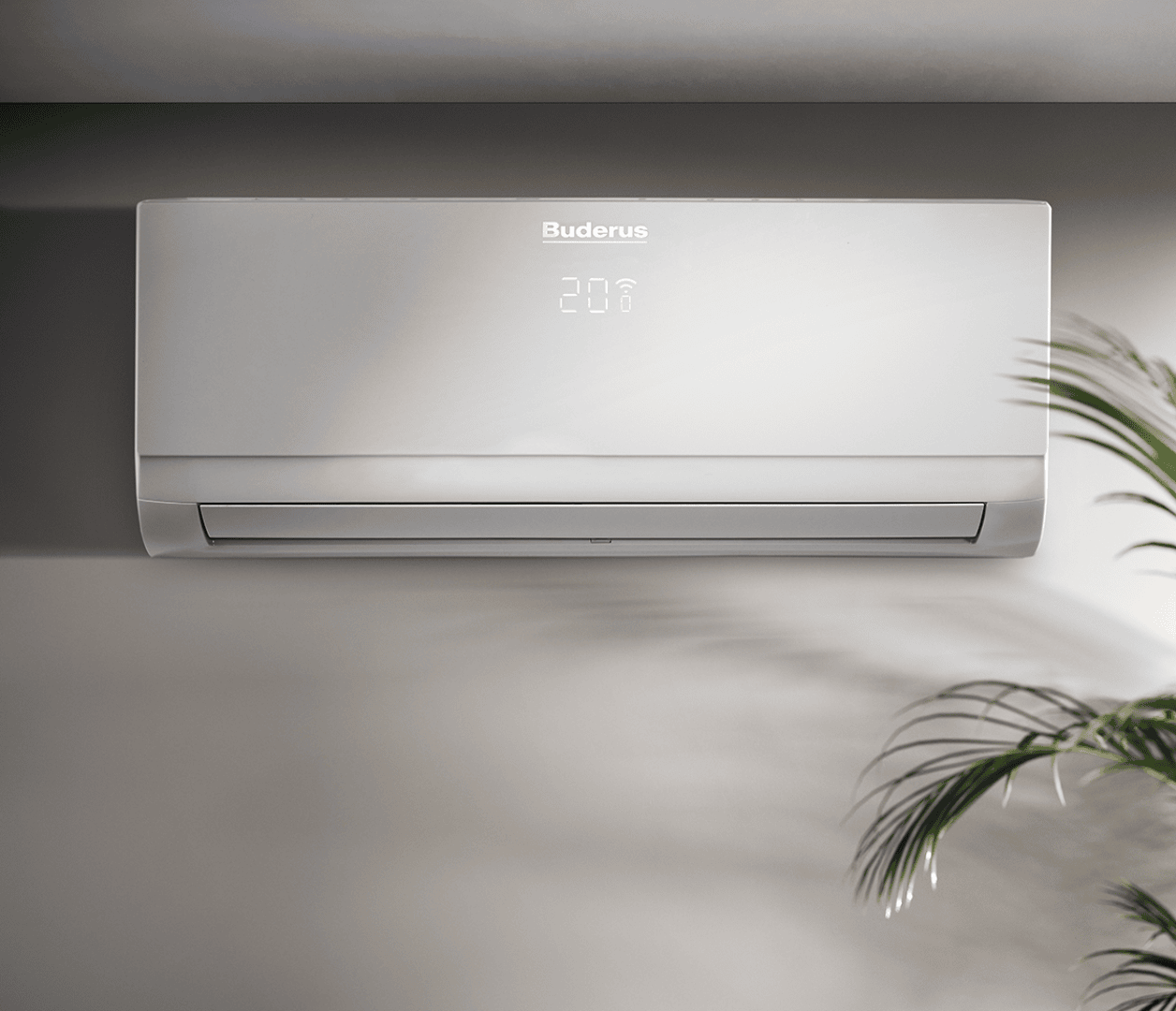 Ein modernes Buderus-Wandklimagerät zeigt eine Temperatur von 20,8 °C an. Das Gerät ist an einer hellen Wand installiert. In der unteren rechten Ecke ist ein Teil einer Grünpflanze zu sehen.