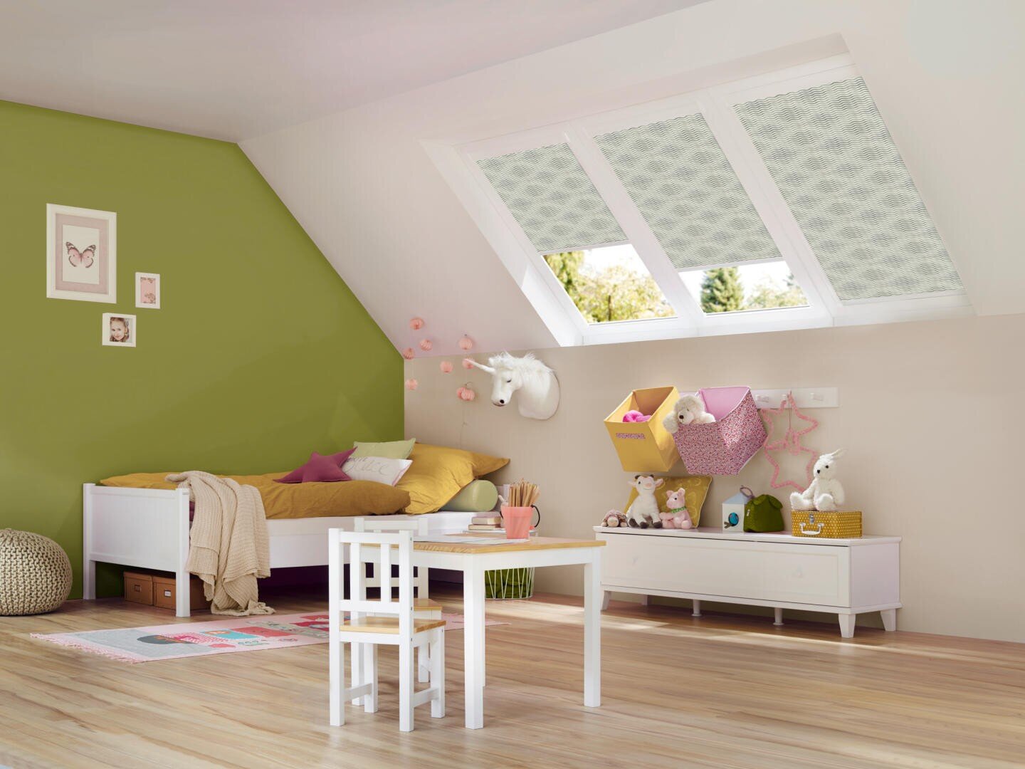 Ein gemütliches, modernes Kinderzimmer mit einer grünen Akzentwand, schrägen Dachfenstern, einem Bett mit gelber Bettwäsche, einem kleinen Tisch und Stühlen sowie Regalen mit Spielzeug, Büchern und Dekorationen. Heller Holzboden.