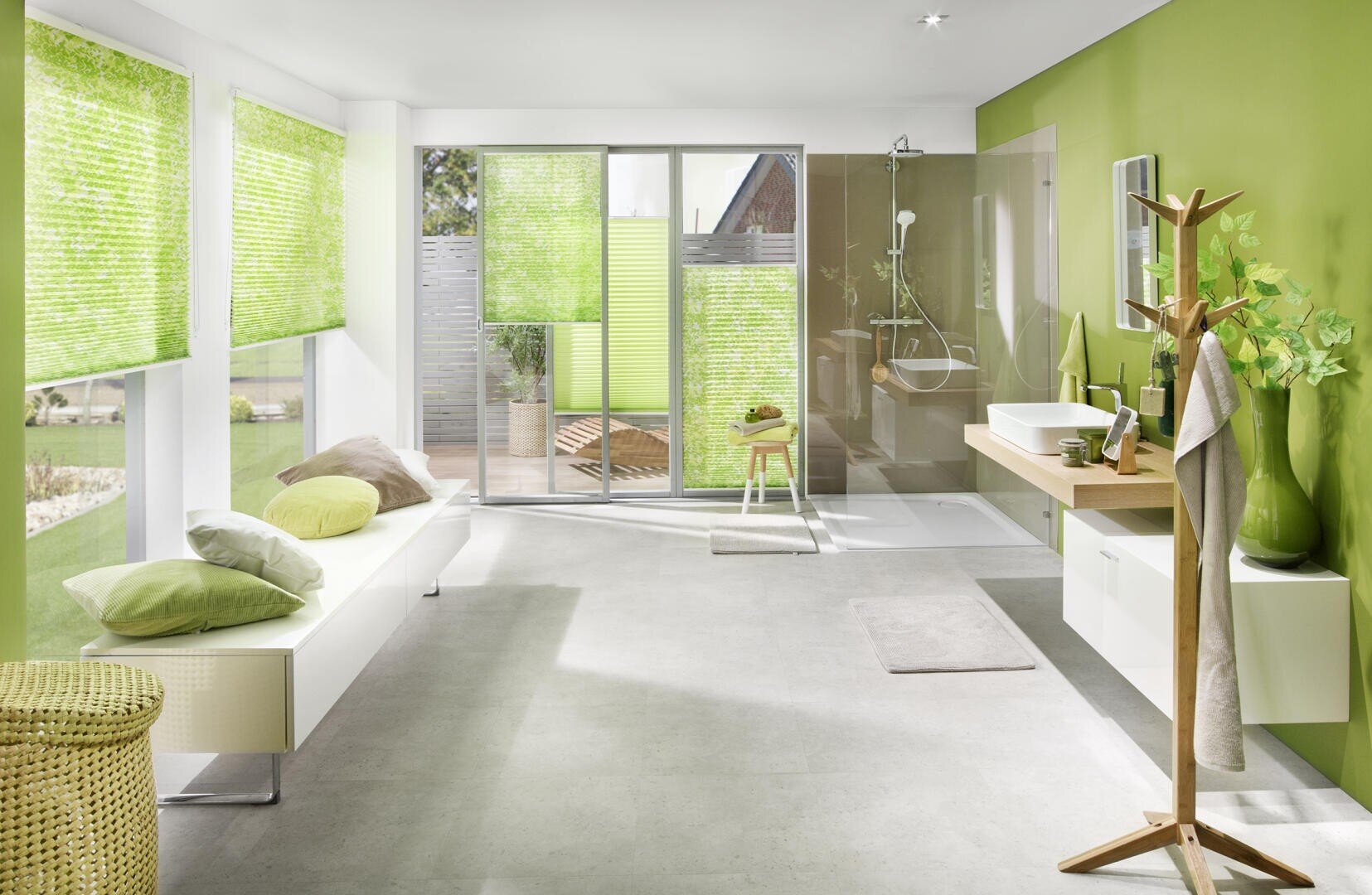 Helles, modernes Badezimmer mit grünen Wänden, weißem und grünem Dekor, großen Fenstern mit grünen Jalousien, einer Bank mit Kissen, einer begehbaren Dusche und einem hölzernen Waschtisch mit Waschbecken und Spiegel. Der Raum ist von natürlichem Licht durchflutet.