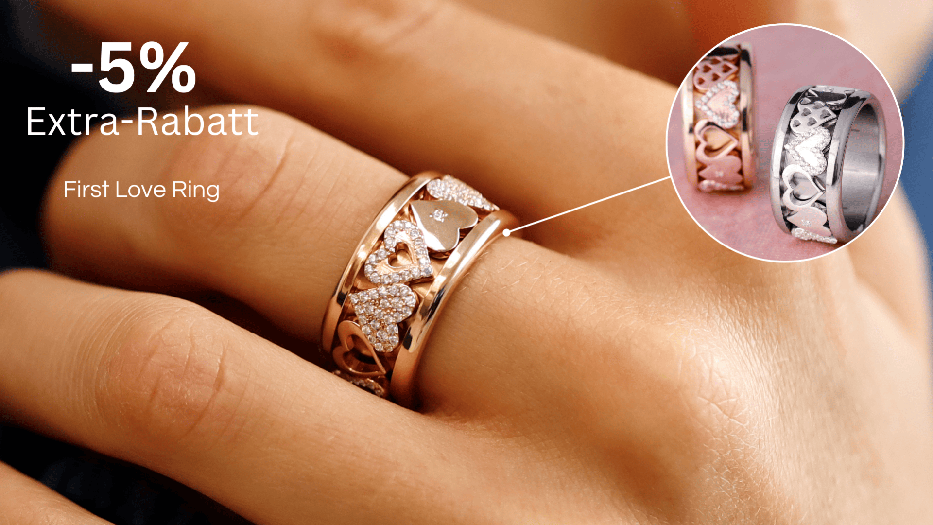 An einer Hand steckt ein Ring aus Roségold und Silber mit Herzmotiven und Diamanten. Der Text lautet: „-5 % Extra-Rabatt, First Love Ring“. Eine Einblendung zeigt eine Nahaufnahme desselben Rings vor einem rosa Hintergrund.