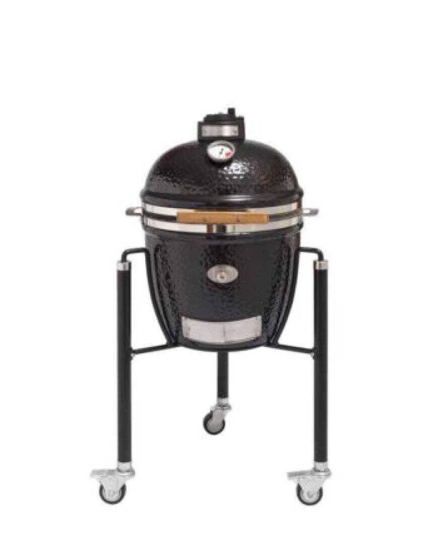 Ein schwarzer Keramikgrill im Kamadostil mit eingebautem Thermometer, der auf einem Metallwagen mit vier Rädern steht, von denen zwei feststellbar sind. Der Grill hat einen gewölbten Deckel und seitliche Griffe.