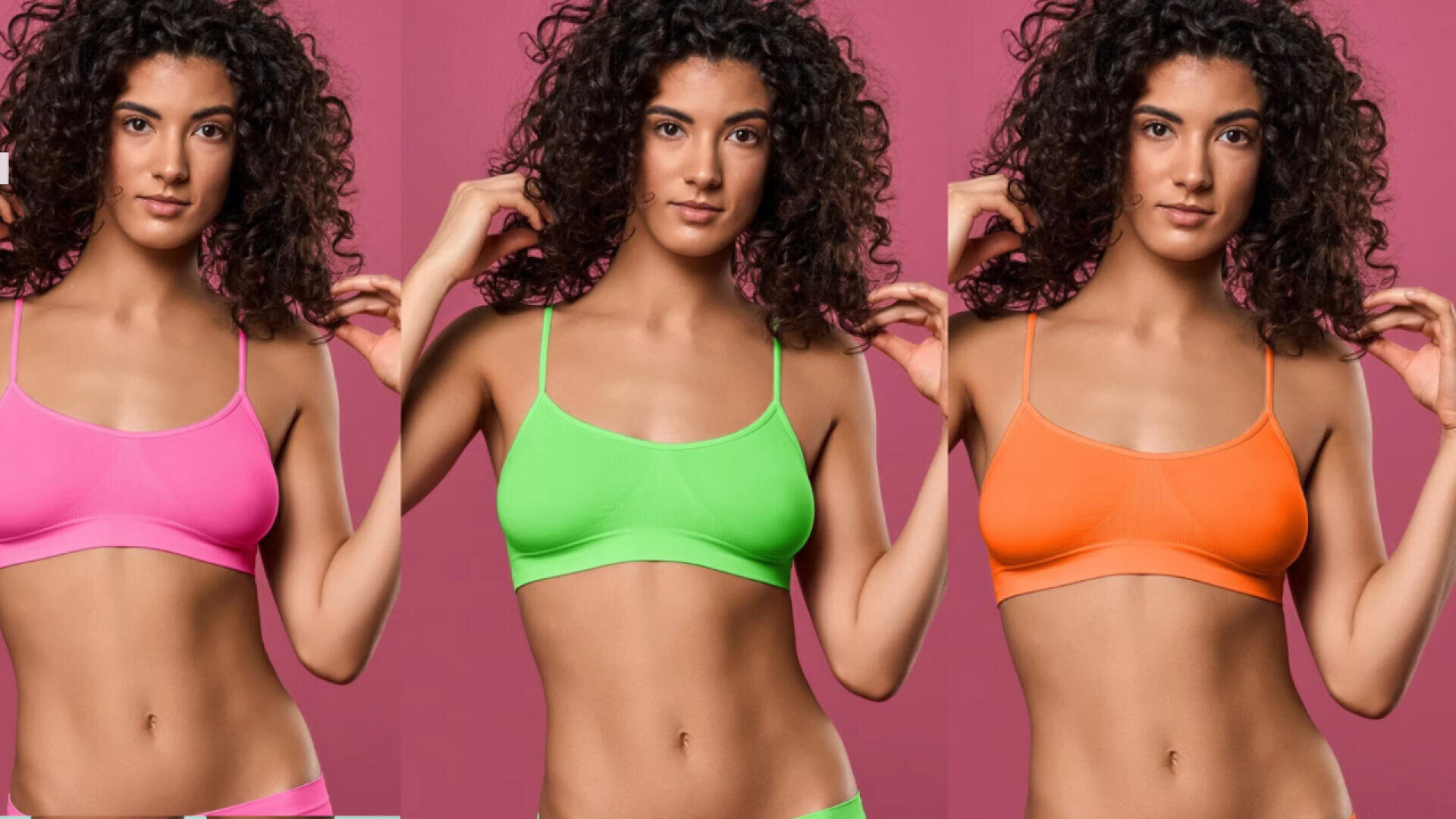 Eine Frau mit lockigem Haar posiert vor einem rosa Hintergrund und trägt drei verschiedenfarbige Bralettes: rosa, grün und orange, die nebeneinander abgebildet sind.