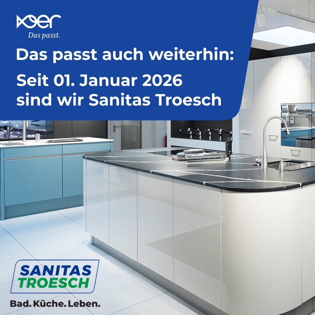 Ein moderner Küchenausstellungsraum mit schlichten weißen und blauen Schränken. Ein Text auf Deutsch kündigt an, dass das Unternehmen ab dem 1. Januar 2026 Sanitas Troesch heißen wird. Das Logo von Sanitas Troesch befindet sich unten links.