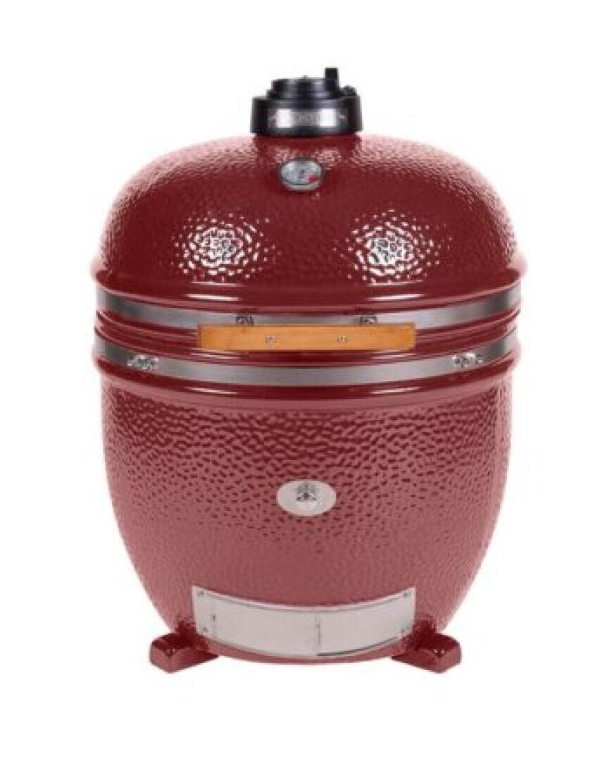 Ein roter, eiförmiger Holzkohlegrill aus Keramik mit strukturierter Oberfläche, Temperaturanzeige und Lüftungsschlitz an der Oberseite, der auf kurzen Beinen steht.