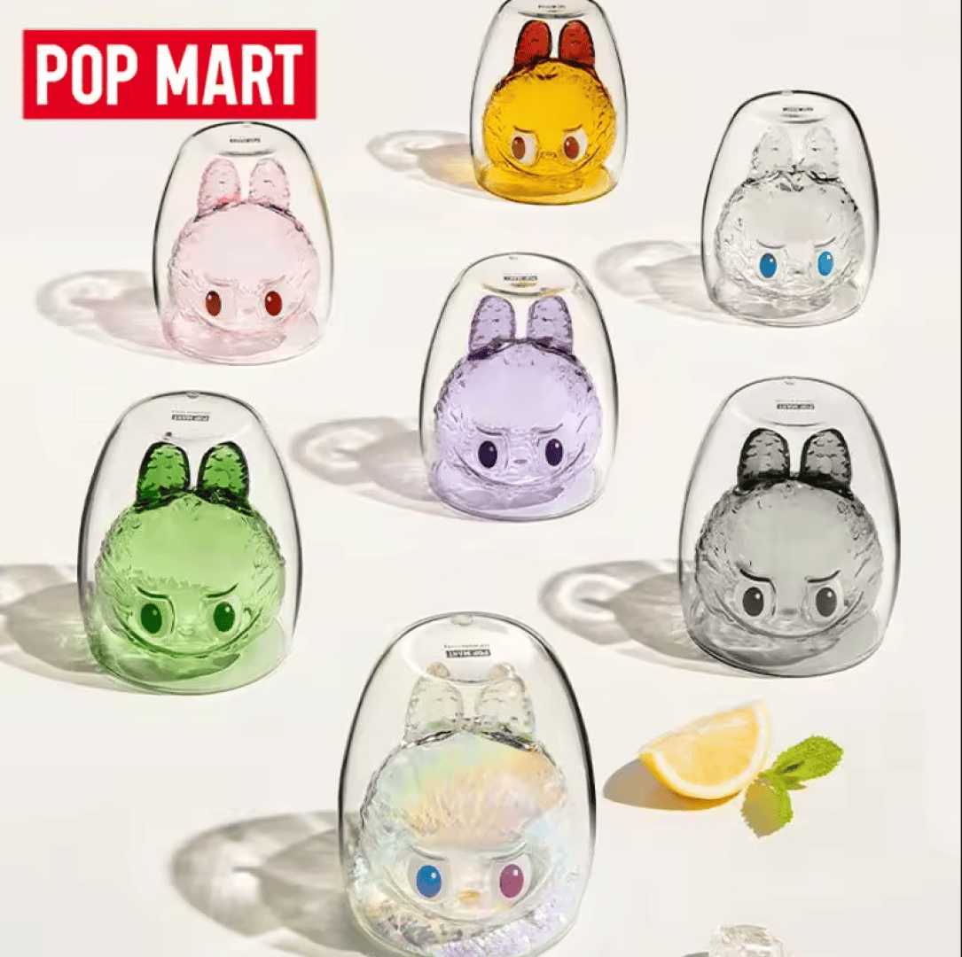 Sieben bunte Hasenfiguren aus Glas mit ausdrucksstarken Gesichtern sind auf einer hellen Fläche angeordnet, daneben liegen eine Zitronenscheibe und Minzblätter. POP MART steht in fetter roter und weißer Schrift in der oberen linken Ecke.