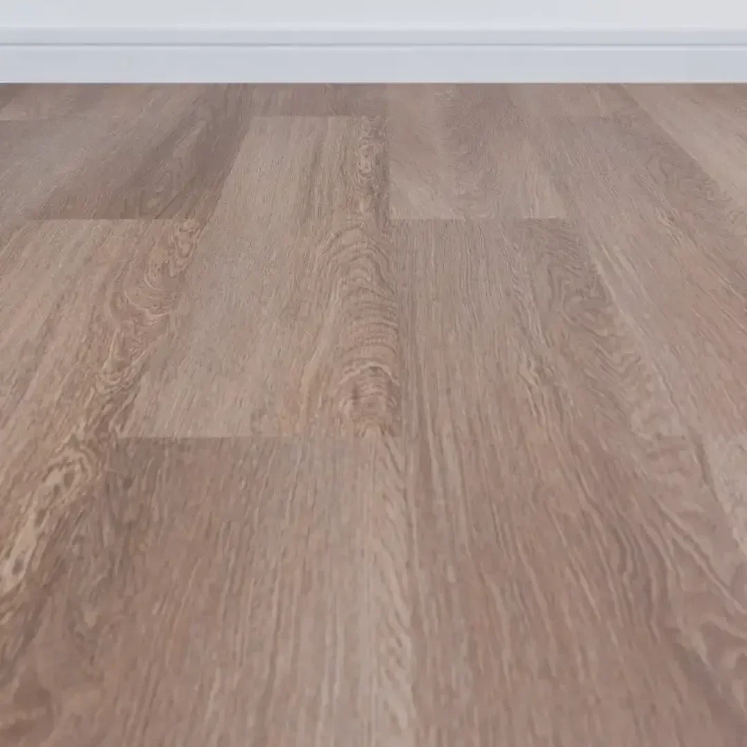 Hellbrauner Laminatfußboden in Holzoptik mit dezenter Maserung, aus der Nähe betrachtet und in Richtung einer weißen Fußleiste und einer glatten Wand im Hintergrund.