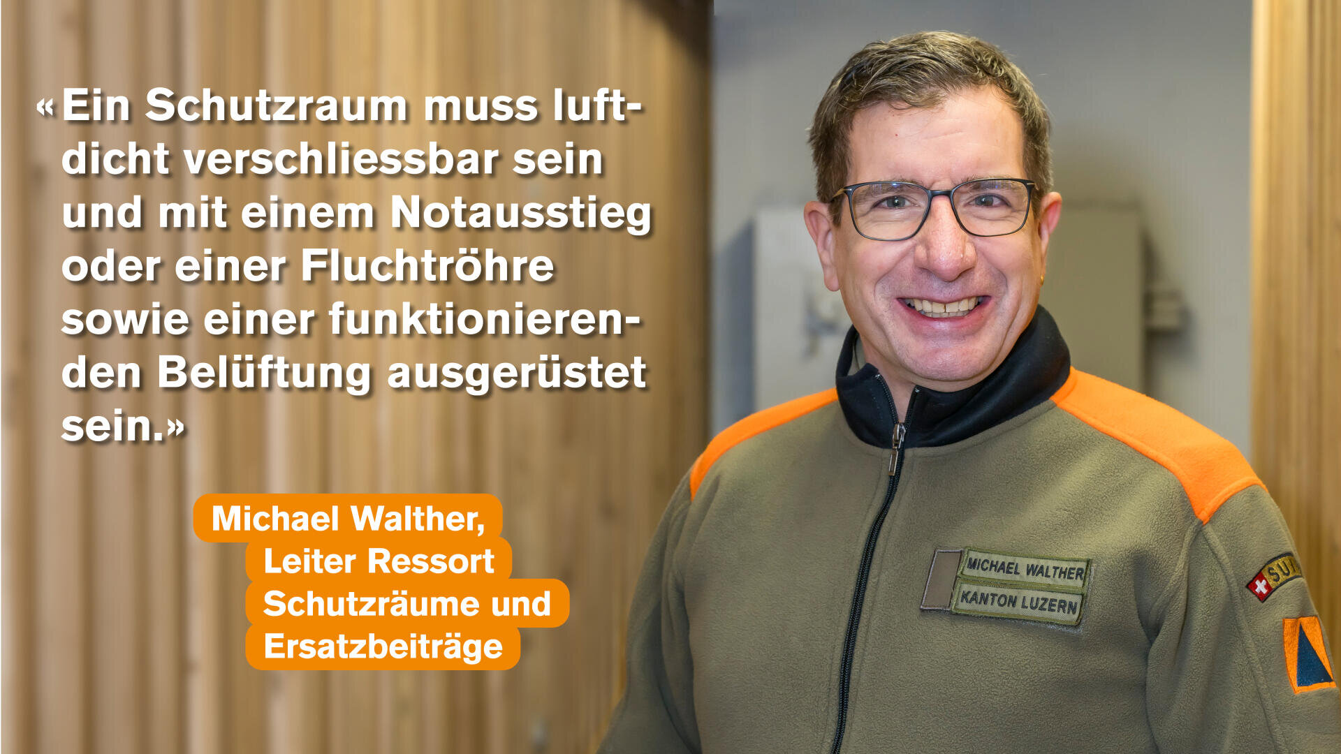 Ein lächelnder Mann in einer Uniform steht in einem Gebäude. Neben ihm steht ein deutsches Zitat über Notunterkünfte, die luftdicht sein müssen und über einen Notausgang, ein Fluchtrohr und eine Lüftung verfügen müssen. Sein Name, Michael Walther, und sein Titel sind in orangefarbenen Kästen angegeben.
