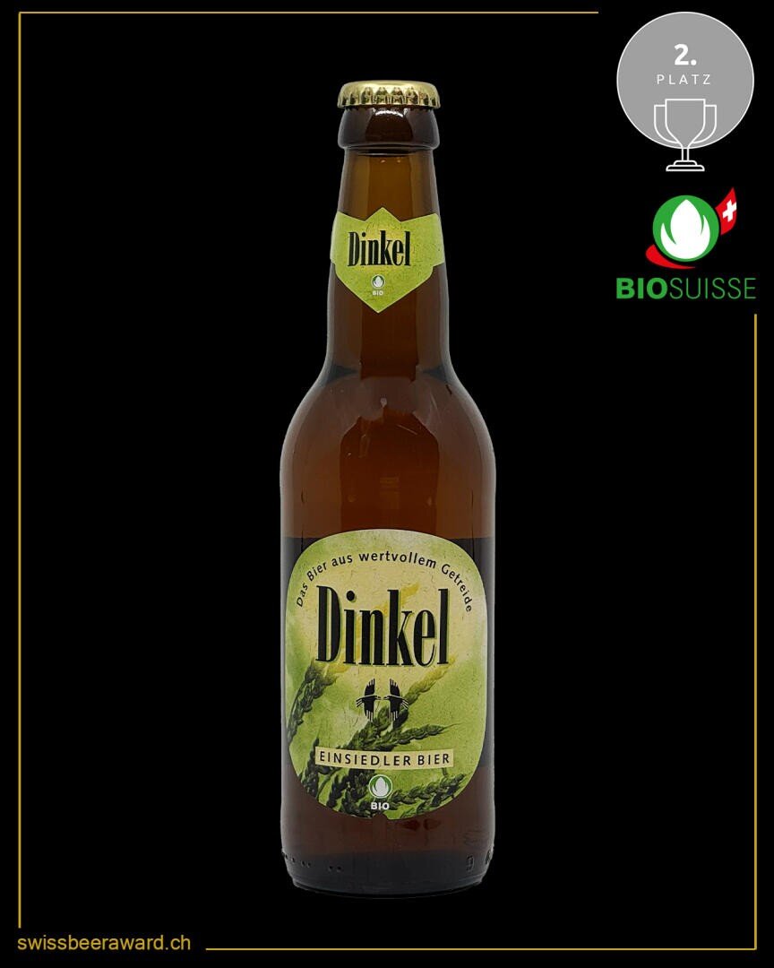 Eine braune Glasflasche von Dinkel Einsiedler Bier mit einem gelben und grünen Etikett. Das Bild zeigt die Bio-Zertifizierung des Bieres und eine silberne 2. Platz Auszeichnungsplakette. Die Website swissbeeraward.ch befindet sich am unteren Rand.