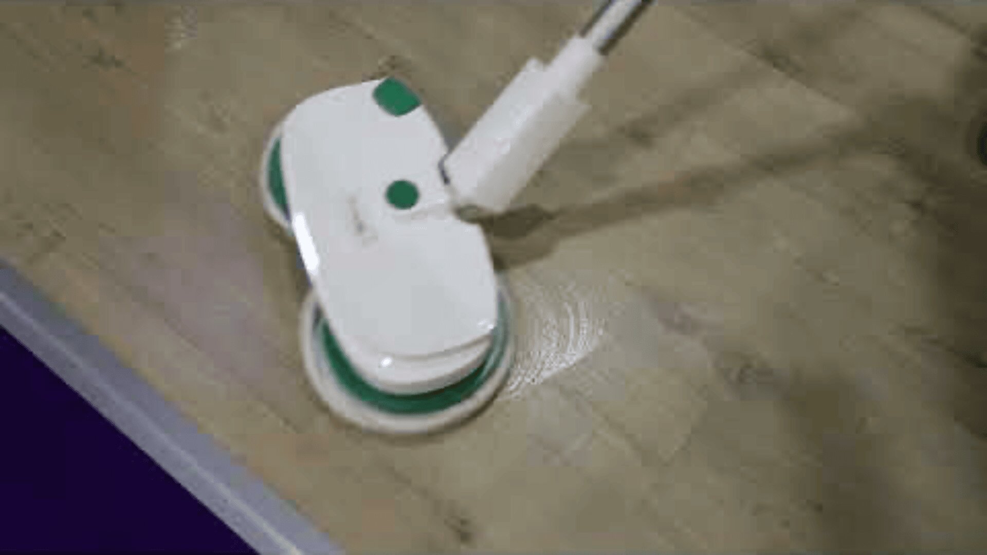 Ein weiß-grüner Elektromopp reinigt einen hellen Holzboden, wobei seine rotierenden Pads sichtbar sind, während er über die Oberfläche gleitet.