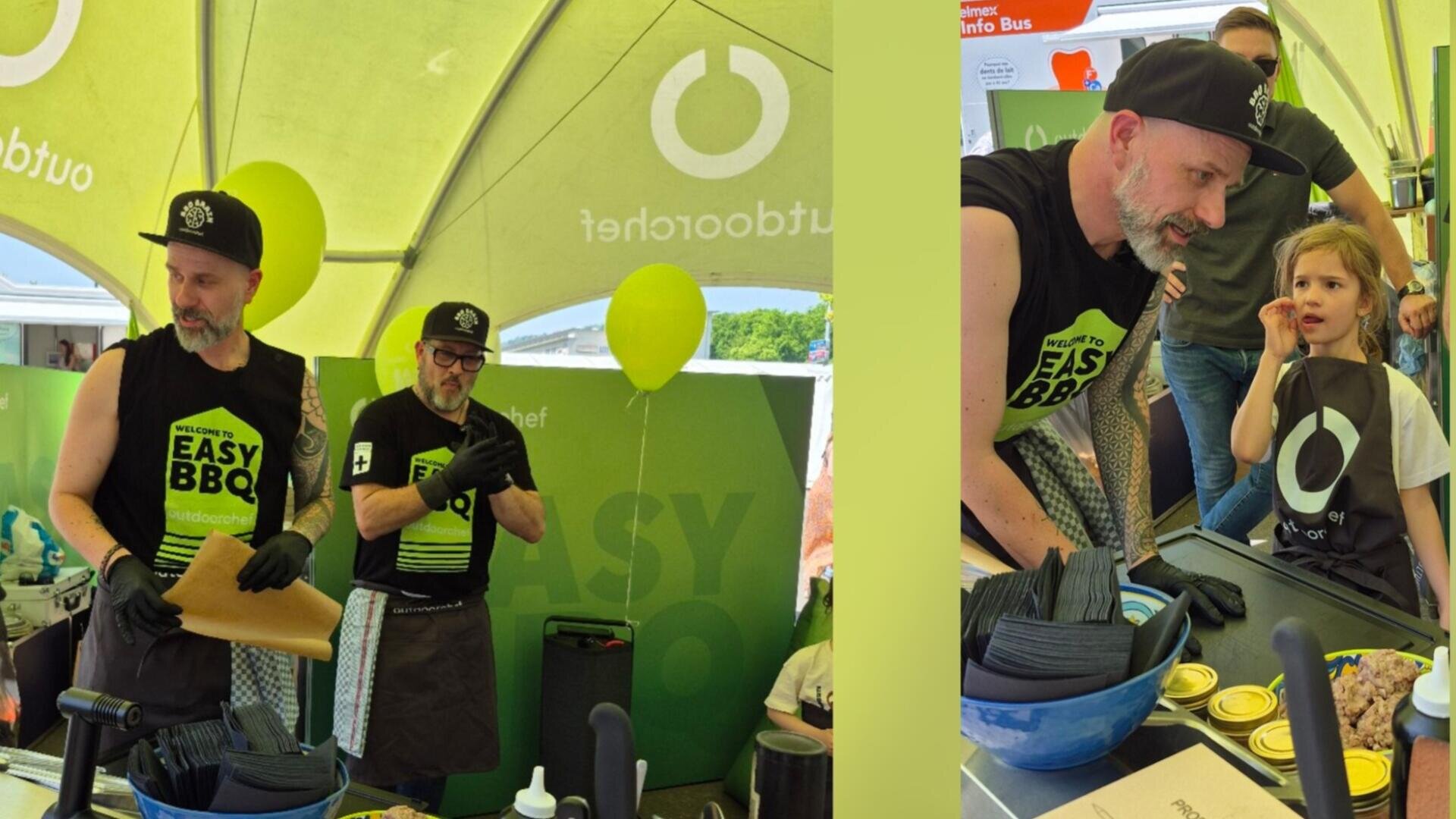 Zwei Männer in schwarzen "Easy BBQ"-Hemden und Hüten demonstrieren unter einem grünen Zelt Grilltechniken. Auf der rechten Seite spricht einer von ihnen mit einem jungen Mädchen, während sie neben Kochutensilien und Gewürzen stehen. Im Hintergrund hängt ein gelber Luftballon.