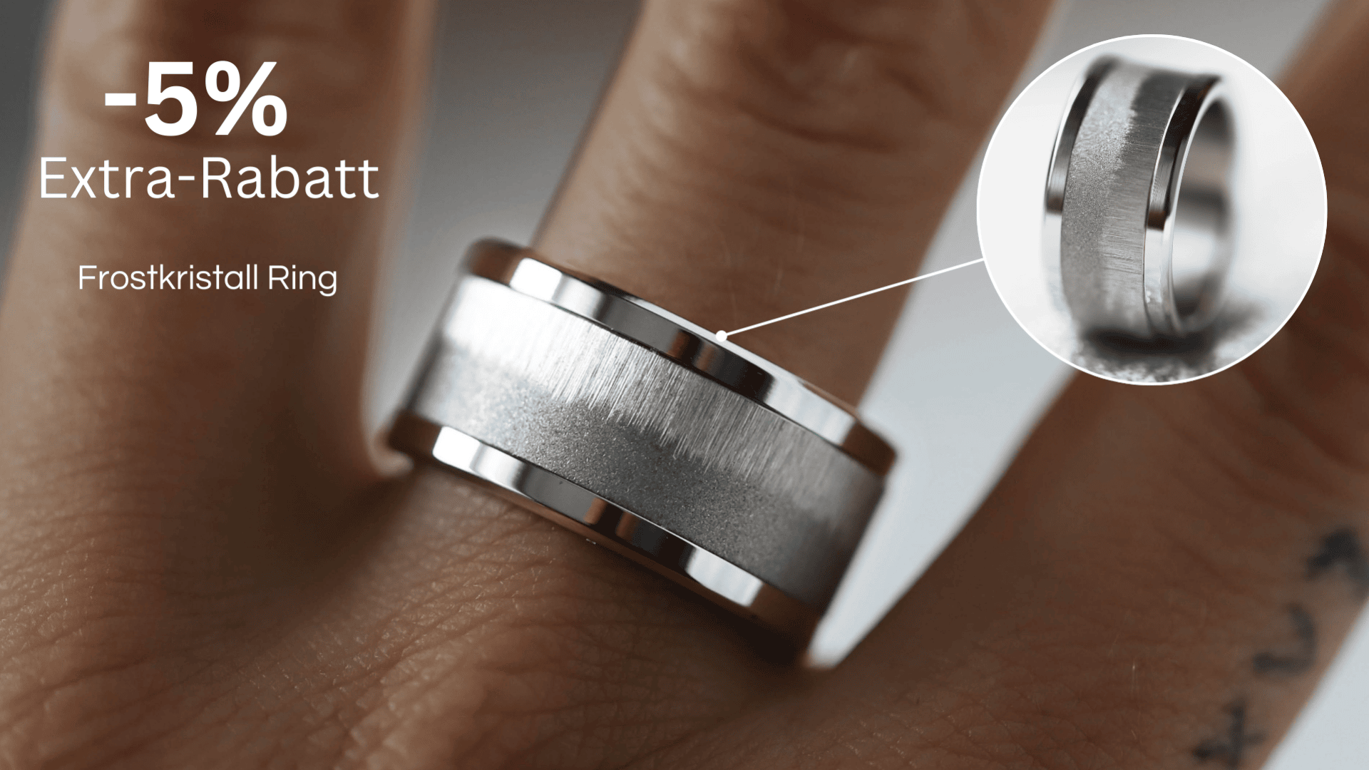 An einer Hand befindet sich ein silberner „Frostkristall“-Ring mit gebürsteter Mitte und polierten Kanten. Ein Text in deutscher Sprache wirbt mit einem zusätzlichen Rabatt von 5 %. Eine Einblendung zeigt eine Nahaufnahme der Ringoberfläche.
