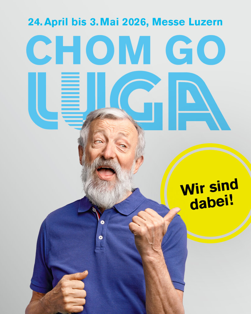 Ein älterer Mann mit grauem Bart und blauem Poloshirt zeigt auf ihn und lächelt. Über ihm steht in blauer Schrift: 24. April bis 3. Mai 2026, Messe Luzern, CHOM GO LUGA. In einem gelben Kreis steht: "Wir sind dabei!.