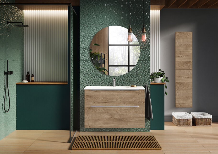 Modernes Badezimmer mit grün strukturierten Wandfliesen, einem runden Spiegel über einem hölzernen Waschtisch, Pendelleuchten, einer begehbaren Dusche und Körben zur Aufbewahrung auf dem Boden. Ein großes Fenster bringt natürliches Licht herein.